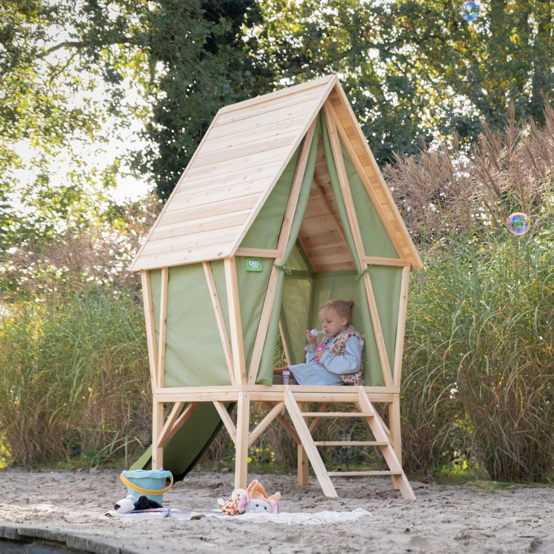 groen houten speelhuis in de tuin