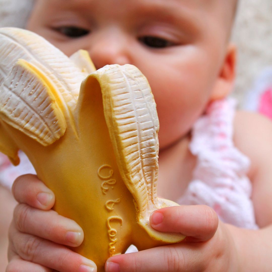 baby speelt met banaan bijtspeeltje