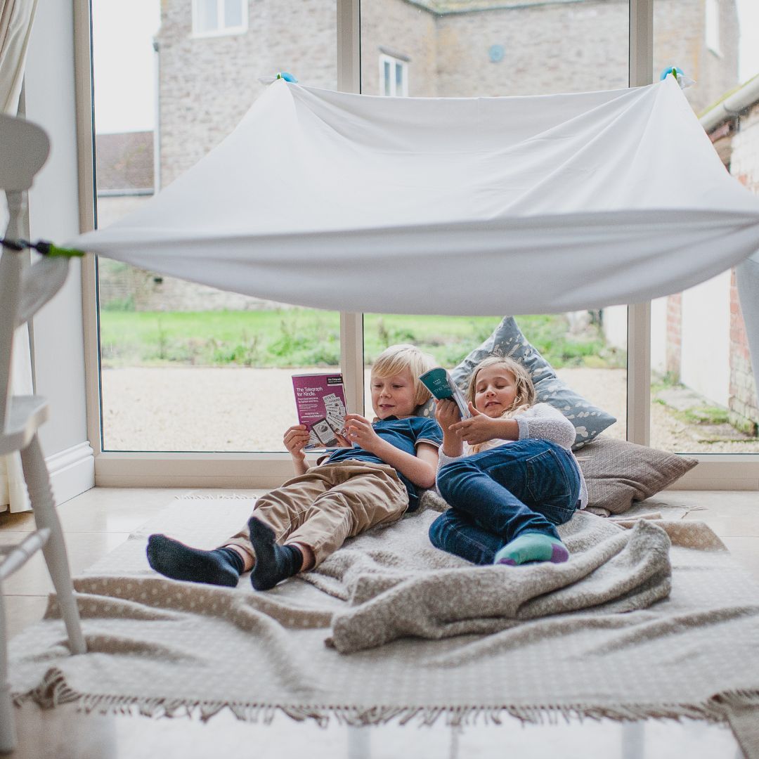 boek lezen onder zelfgebouwde tent